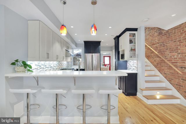 a kitchen with a white cabinets and chandelier