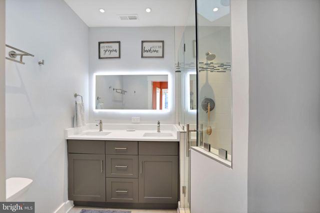 a bathroom with a double vanity sink a mirror and a shower