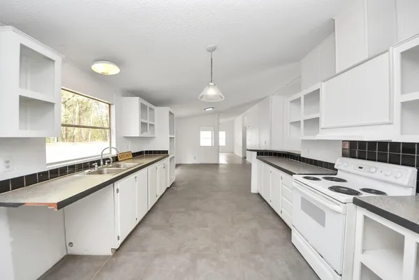 a kitchen that has a stove and white cabinets