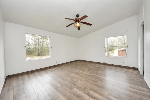a view of room with wooden floor and ceiling fan