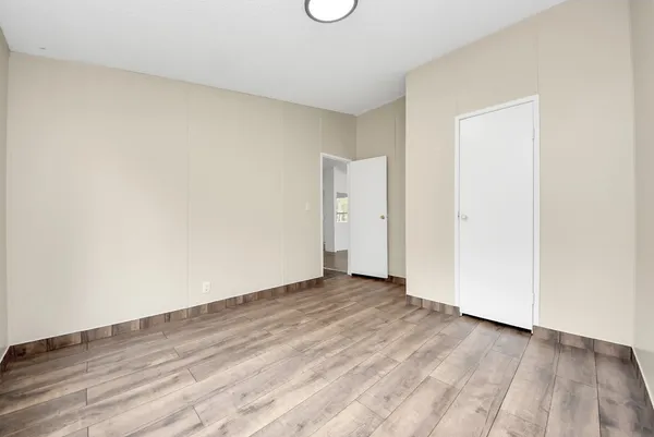 an empty room with a window and a fan