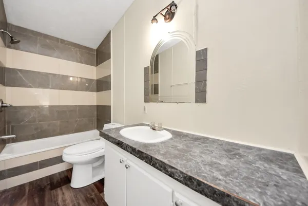 a bathroom with a granite countertop sink and a mirror