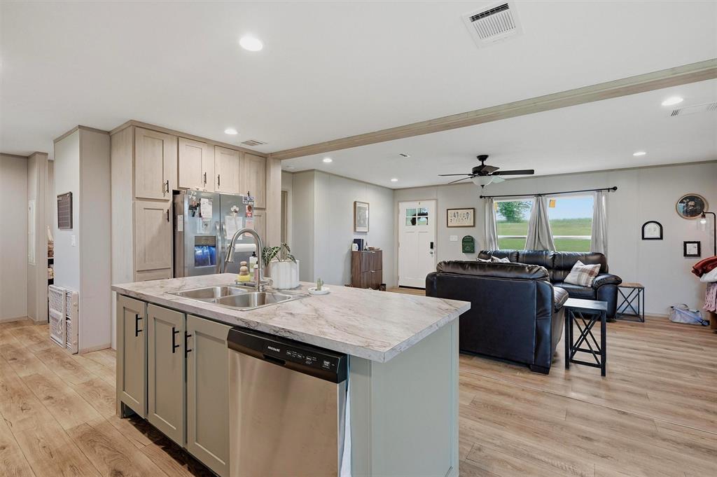 587 Kentucky Town Road Whitewright, TX 75491 - Photo 8 of 39 a kitchen with stainless steel appliances granite countertop a sink stove and wooden floor