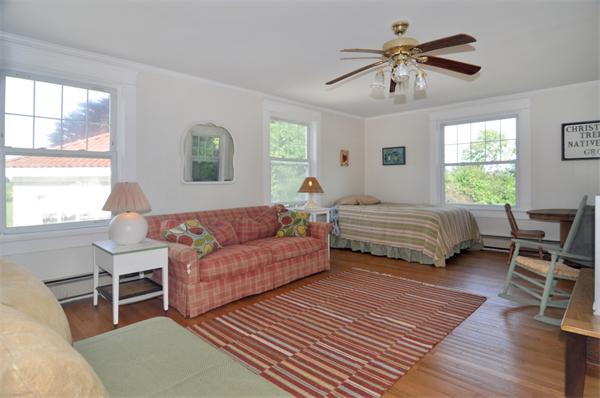 5 Highland Road Tiverton, RI 02878 - Photo 10 of 26 a bedroom with a bed a chandelier and a window