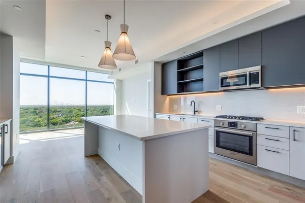 a kitchen with kitchen island granite countertop a sink and a stove top oven