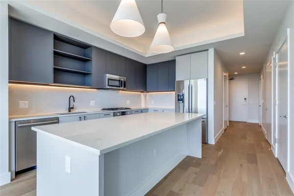a kitchen with stainless steel appliances a sink and a refrigerator