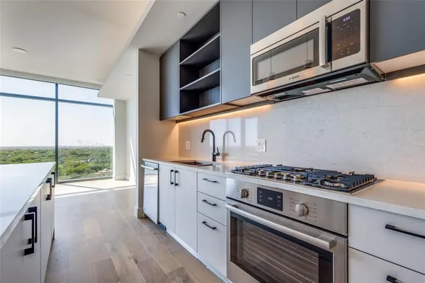 a kitchen with stainless steel appliances granite countertop a stove and a microwave