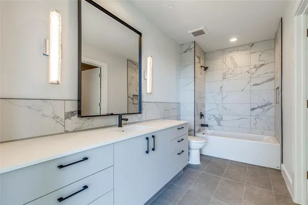 a spacious bathroom with a bathtub sink and mirror