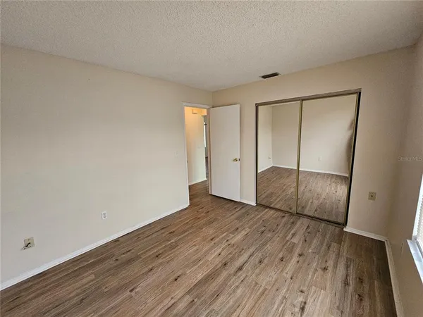 an empty room with wooden floor and entrance