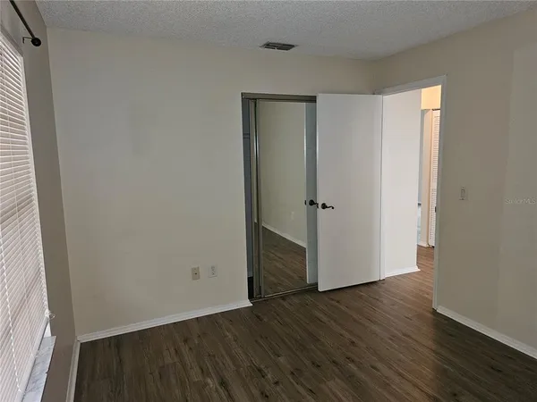 an empty room with wooden floor and closet