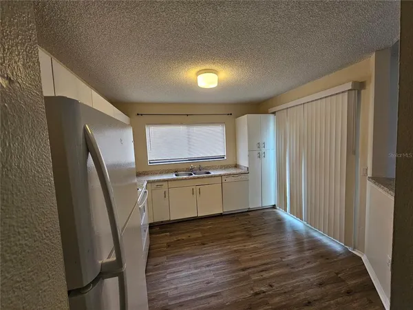 a kitchen with stainless steel appliances a refrigerator sink and wooden floor