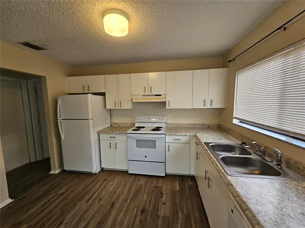 a kitchen with a stove a sink and a refrigerator
