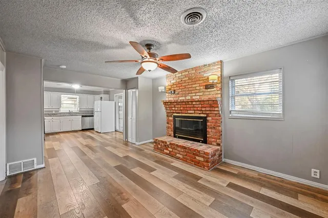 a living room with a fireplace furniture a ceiling fan and a rug
