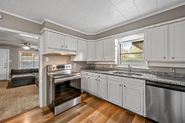a kitchen with granite countertop cabinets stainless steel appliances and a sink