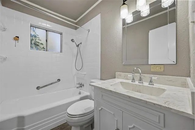 a bathroom with a granite countertop sink a toilet and a mirror