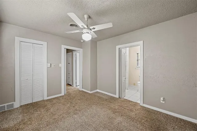 a view of a big room with closet and a chandelier fan