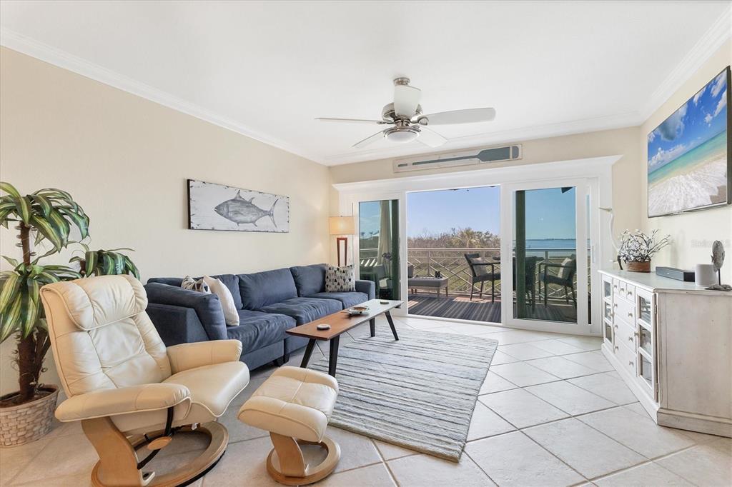 11000 Placida Road, Unit 302 Placida, FL 33946 - Photo 7 of 48 a living room with furniture large windows a rug and a fireplace