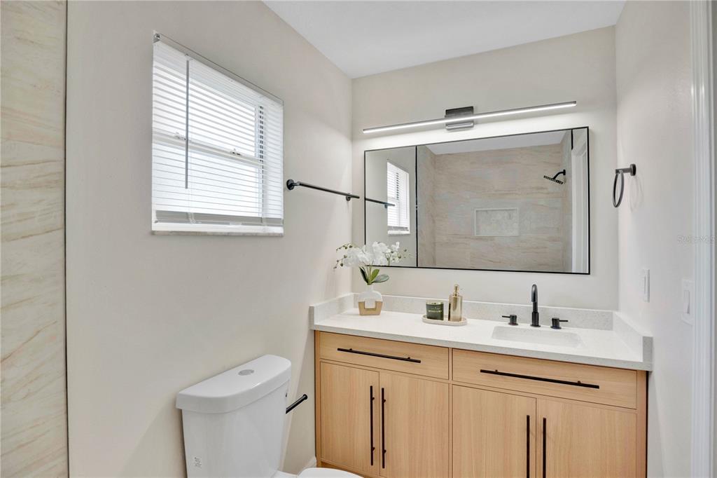 1842 Umbrella Tree Drive Edgewater, FL 32141 - Photo 16 of 32 a bathroom with a toilet sink and mirror