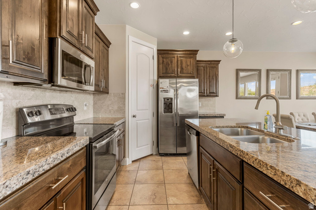 4257 Razor Drive Washington, UT 84780 - Photo 26 of 58 Kitchen featuring stainless steel appliances, wood cabinetry, stone countertops, and tile flooring