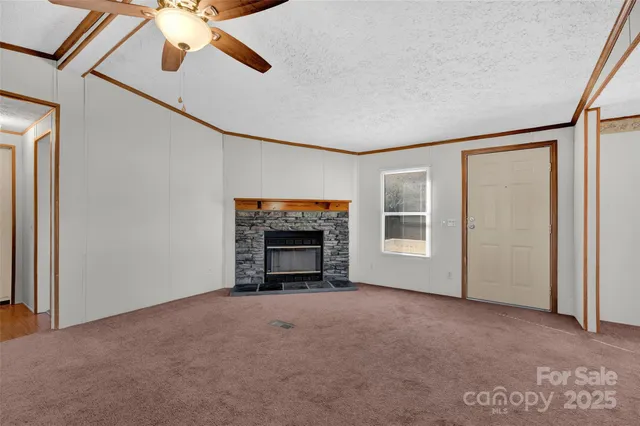 a view of an empty room with a fireplace and a window