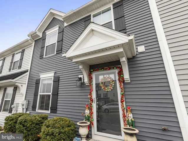 a view of a house with large windows and flower plants