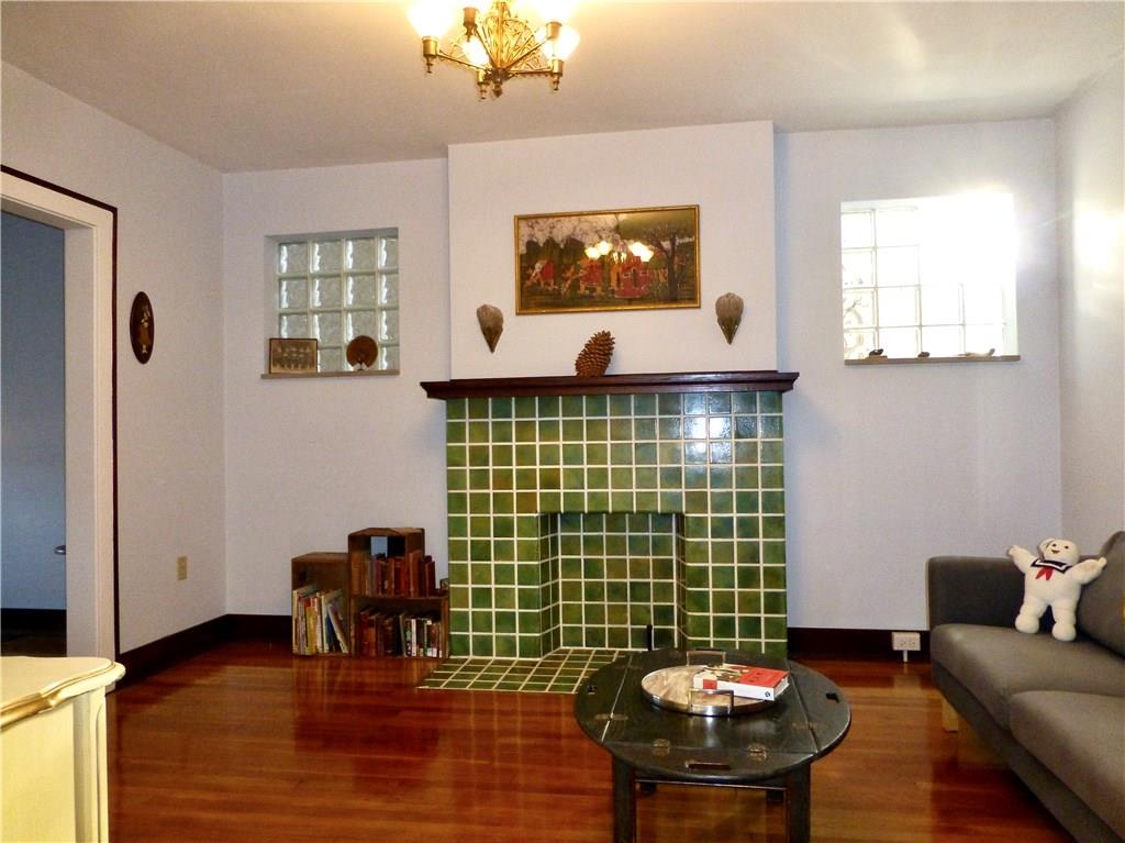 526 Ridge Avenue East Pittsburgh, PA 15112 - Photo 5 of 25 14x12 living has a decorative fireplace, glass block windows, and hardwood floors.