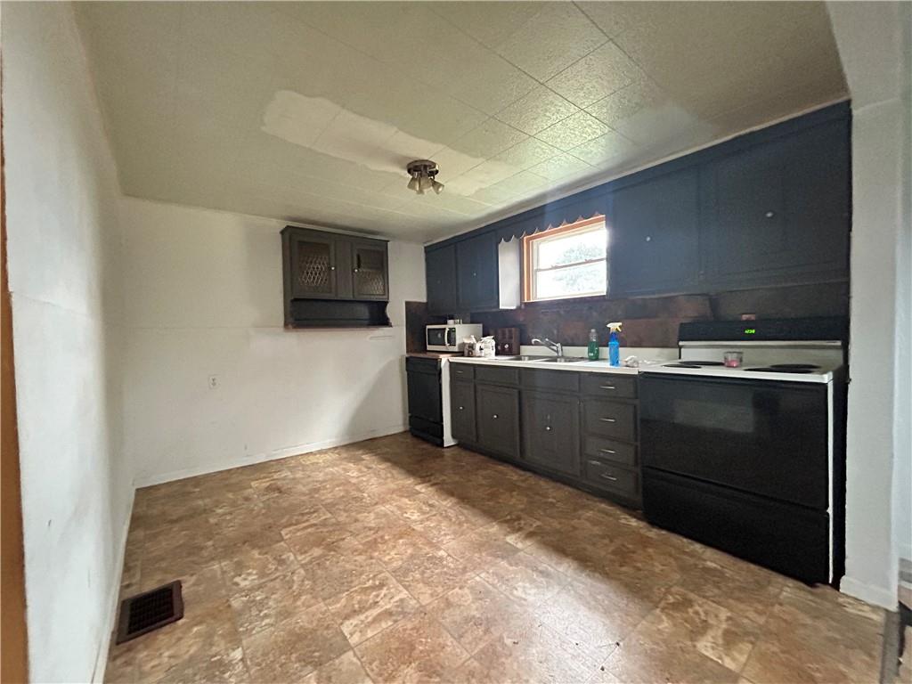 1347 High Road Clairton, PA 15025 - Photo 5 of 21 a kitchen with stainless steel appliances granite countertop a sink a stove a refrigerator with grey cabinets and a refrigerator