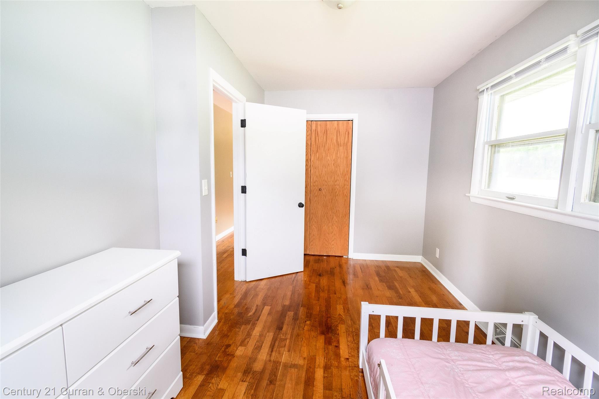 5260 Rives Junction Road Jackson, MI 49201 - Photo 25 of 44 Hardwood flooring throughout, light gray wall paint, white trim, and a double window