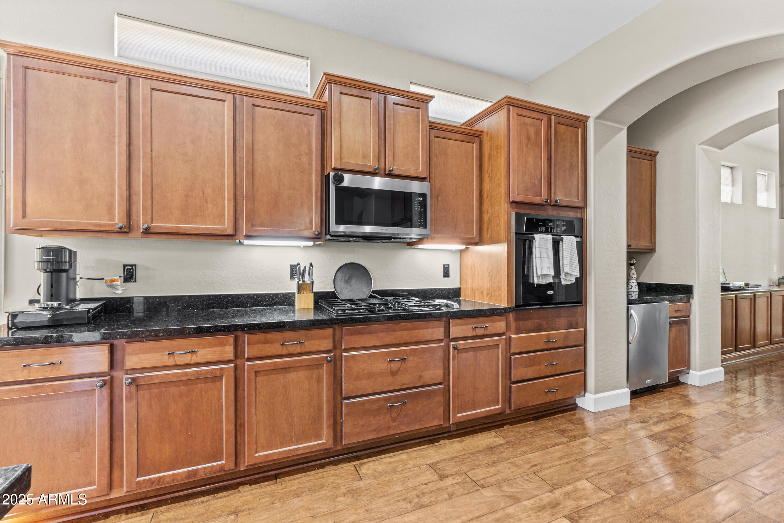 2879 East Janelle Way Gilbert, AZ 85298 - Photo 6 of 33 a kitchen with stainless steel appliances granite countertop a stove a sink and a microwave