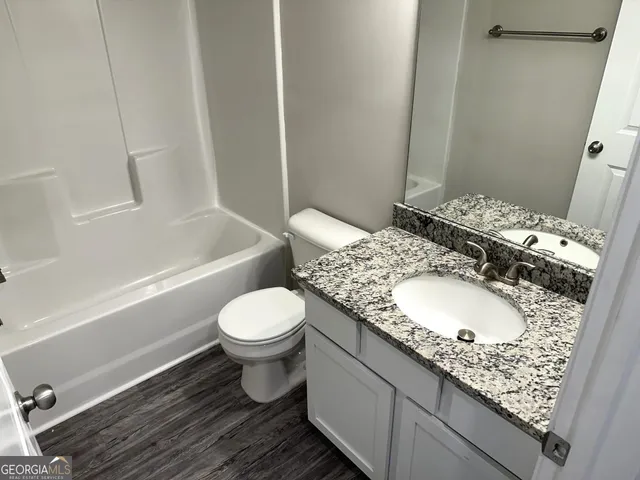 a bathroom with a granite countertop sink toilet and shower