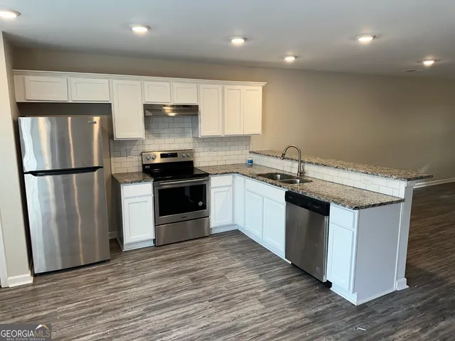 a kitchen with stainless steel appliances granite countertop a sink stove and refrigerator