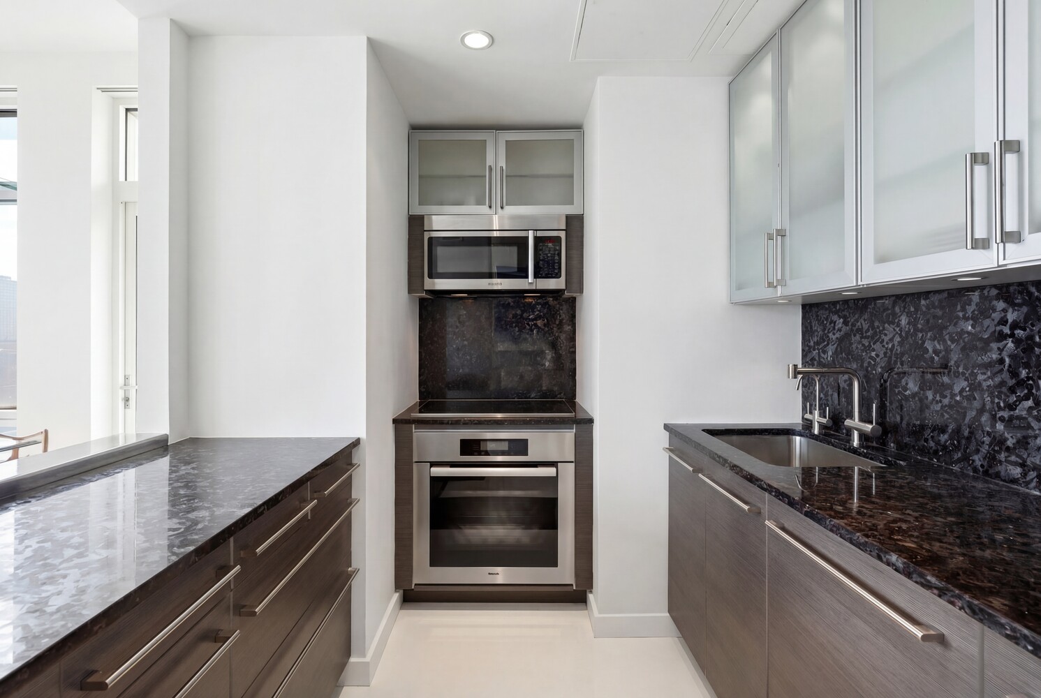 301 West 57th Street, Unit 52C Manhattan, NY 10019 - Photo 6 of 13 a kitchen with granite countertop a stove and a sink