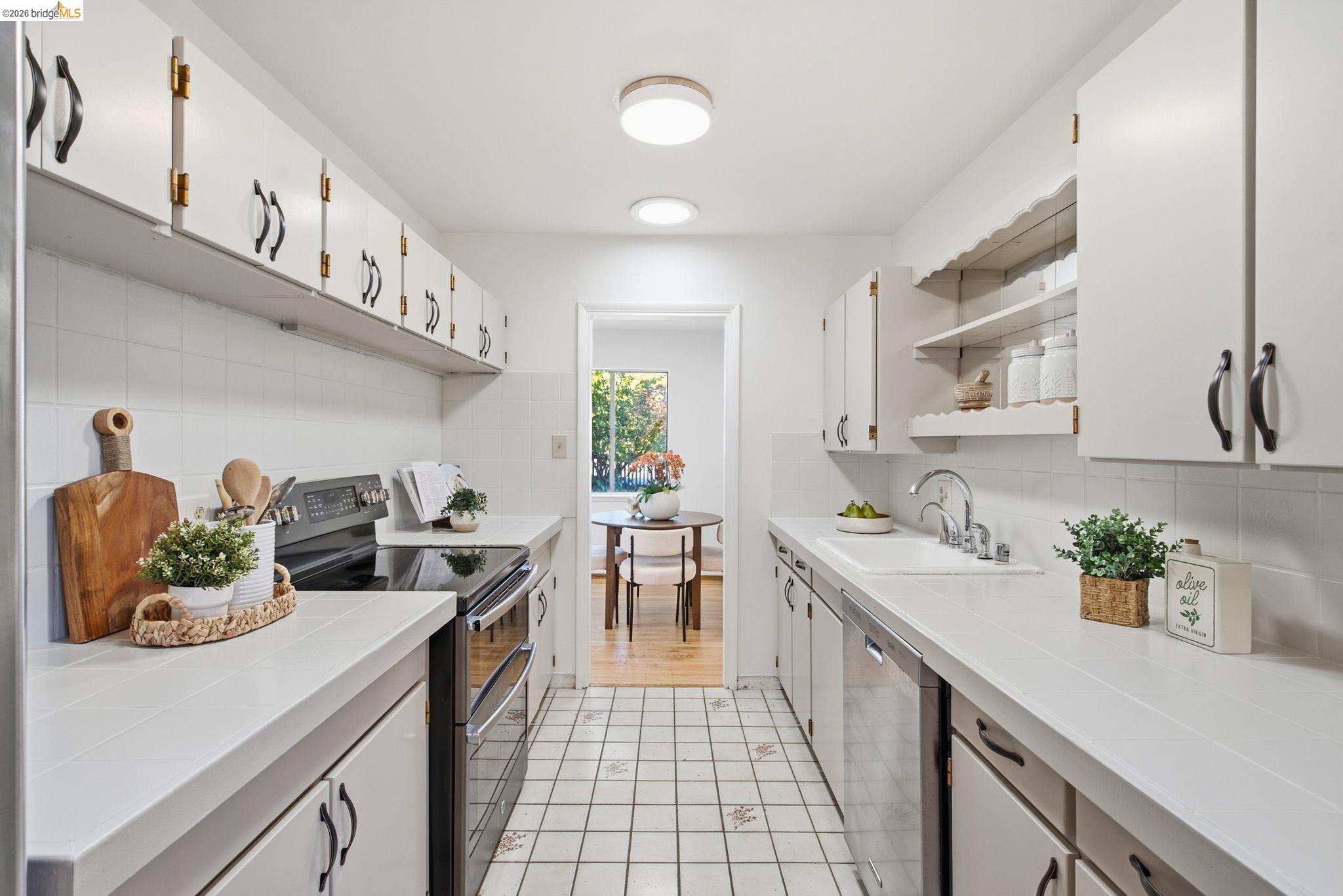 4522 Santa Rita Road El Sobrante, CA 94803 - Photo 11 of 58 Galley kitchen featuring white cabinetry, solid surface countertops, tile flooring, and integrated appliances