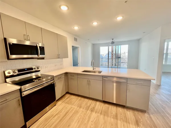 a kitchen with stainless steel appliances a stove sink microwave and cabinets