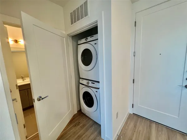 a utility room with wooden floor and washing machine