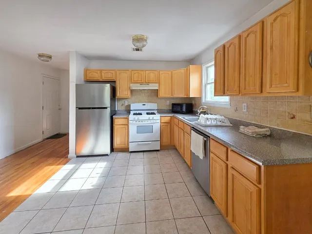 a kitchen with a sink a counter top space cabinets and stainless steel appliances