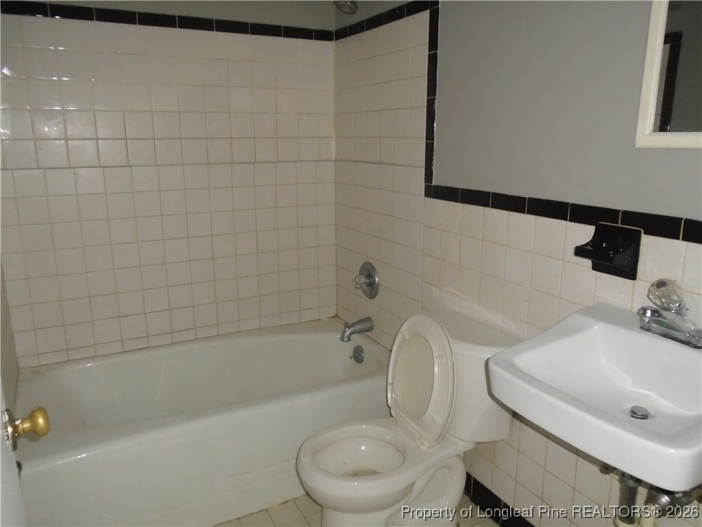 611 Drypoint Lane, Unit 1 Hope Mills, NC 28348 - Photo 11 of 15 a white toilet sitting next to a bath tub