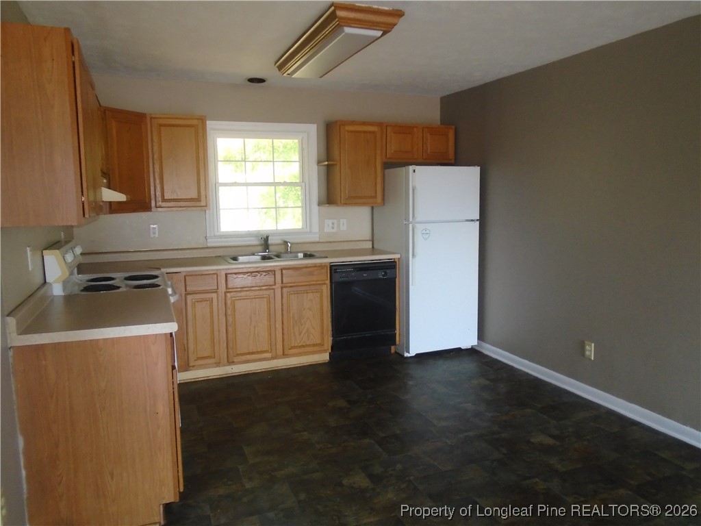 611 Drypoint Lane, Unit 1 Hope Mills, NC 28348 - Photo 5 of 15 a kitchen with stainless steel appliances a sink a stove a refrigerator and cabinets