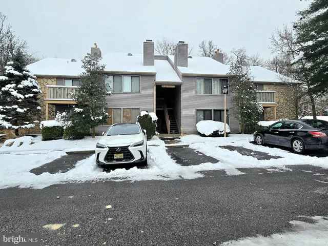 a front view of a house with a yard and car parked