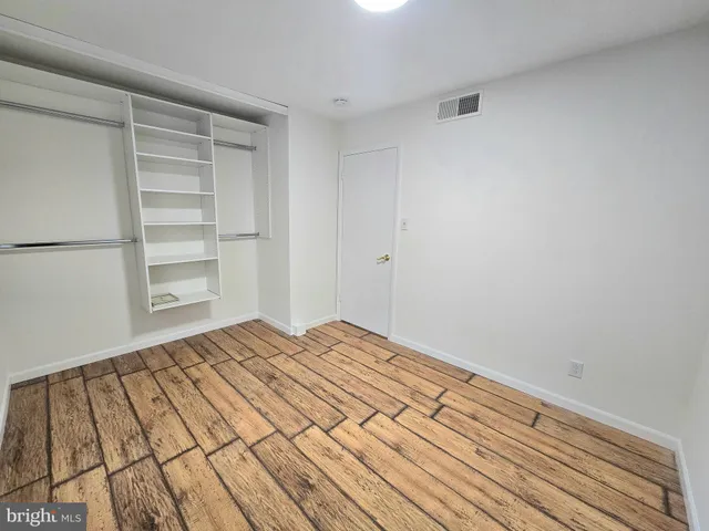a view of empty room with wooden floor