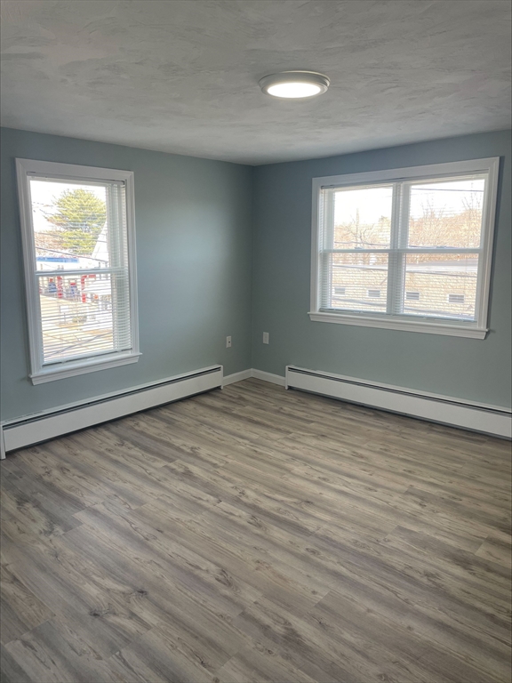 50 Main Street, Unit 3 Woburn, MA 01801 - Photo 6 of 8 a view of an empty room with wooden floor and a window