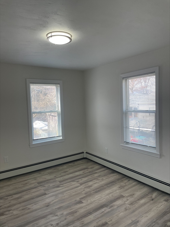 50 Main Street, Unit 3 Woburn, MA 01801 - Photo 7 of 8 an empty room with wooden floor and windows