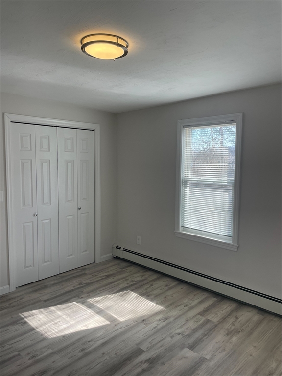 50 Main Street, Unit 3 Woburn, MA 01801 - Photo 8 of 8 an empty room with wooden floor and windows