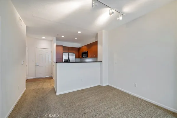 a view of a hallway with bathroom and mirror
