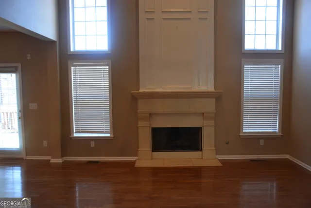 a kitchen with stainless steel appliances granite countertop a refrigerator a sink dishwasher a stove and a dining table with wooden floor