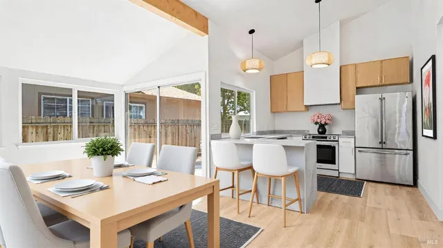 a kitchen with a refrigerator a table and chairs in it
