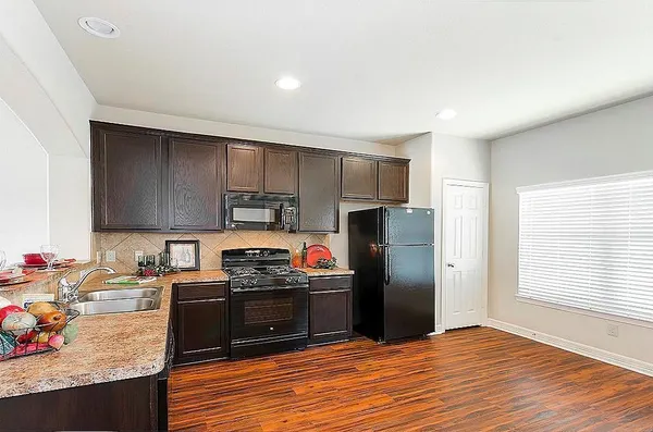 a kitchen with stainless steel appliances granite countertop a refrigerator stove and sink