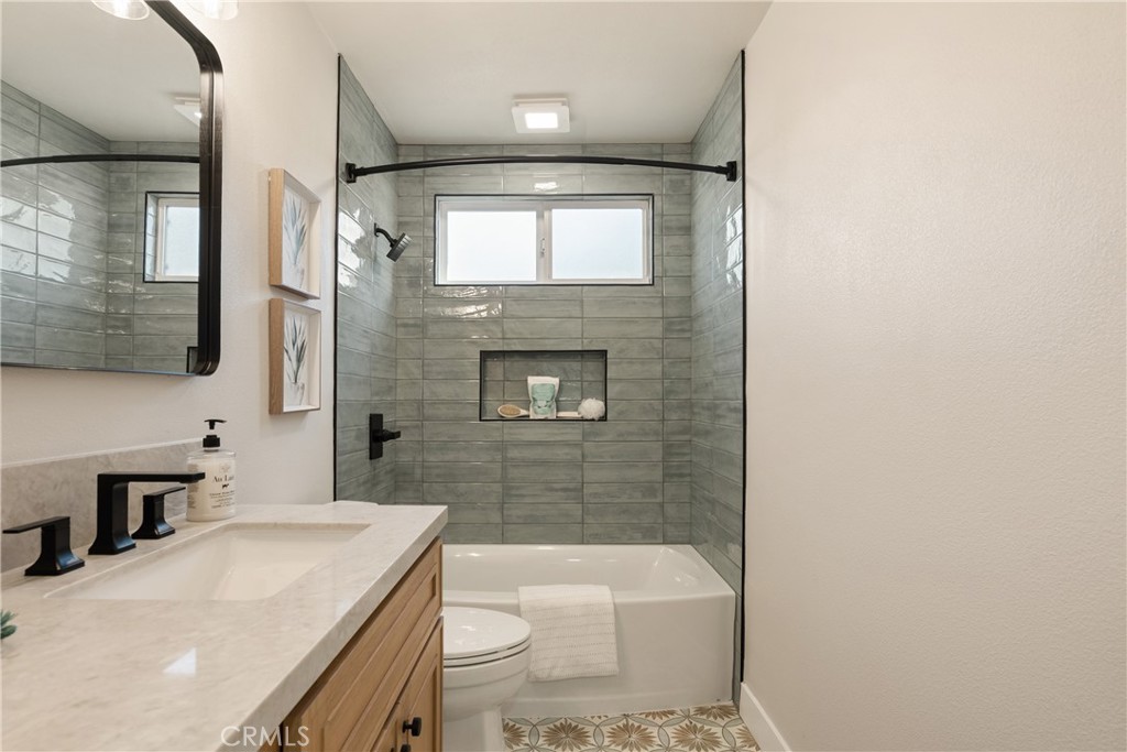 13601 Carroll Way Tustin, CA 92780 - Photo 12 of 28 a bathroom with a sink a toilet a mirror and bathtub