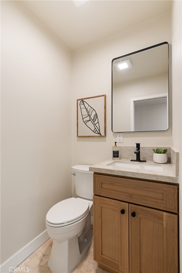 13601 Carroll Way Tustin, CA 92780 - Photo 15 of 28 a bathroom with a toilet a sink a vanity and mirror
