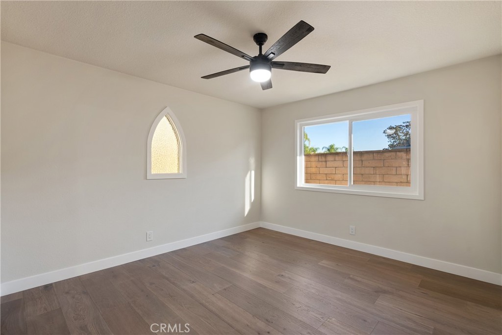 13601 Carroll Way Tustin, CA 92780 - Photo 17 of 28 an empty room with wooden floor ceiling fan and windows